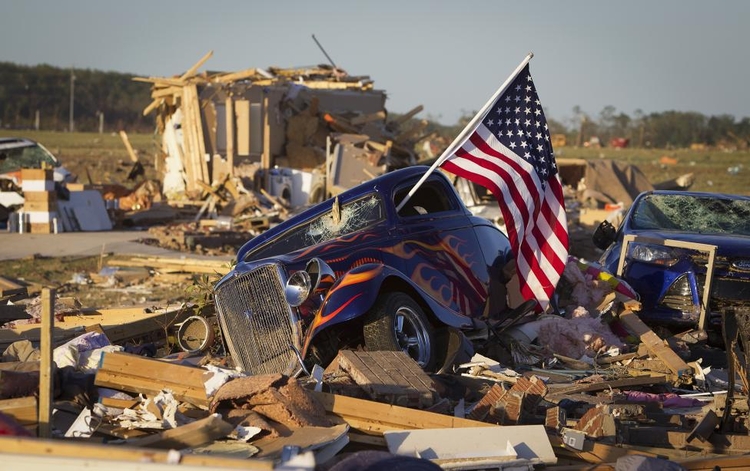fot. Carlo Allegri / Reuters / 28 kwietnia 2014  Velonia, Stany Zjednoczone  Flaga amerykańska wystaje przez okno uszkodzonego samochodu. Pojazd został zdemolowany przez tornado.